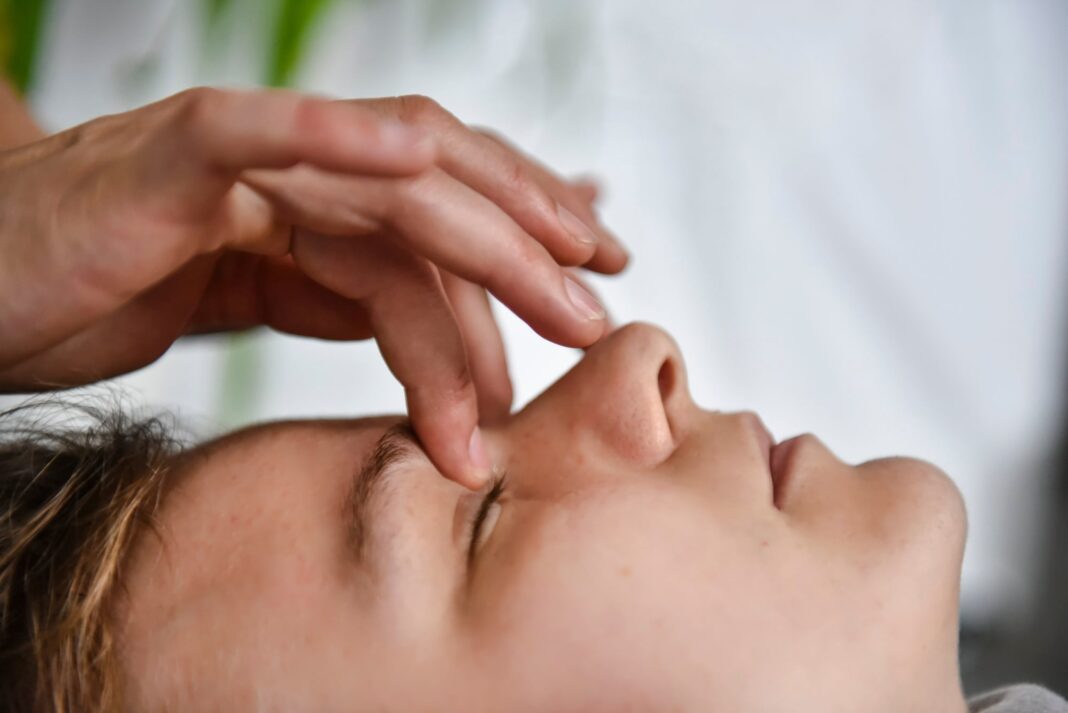 Persona recibiendo una sesión de Access Bars, con toques suaves en puntos de la cabeza.