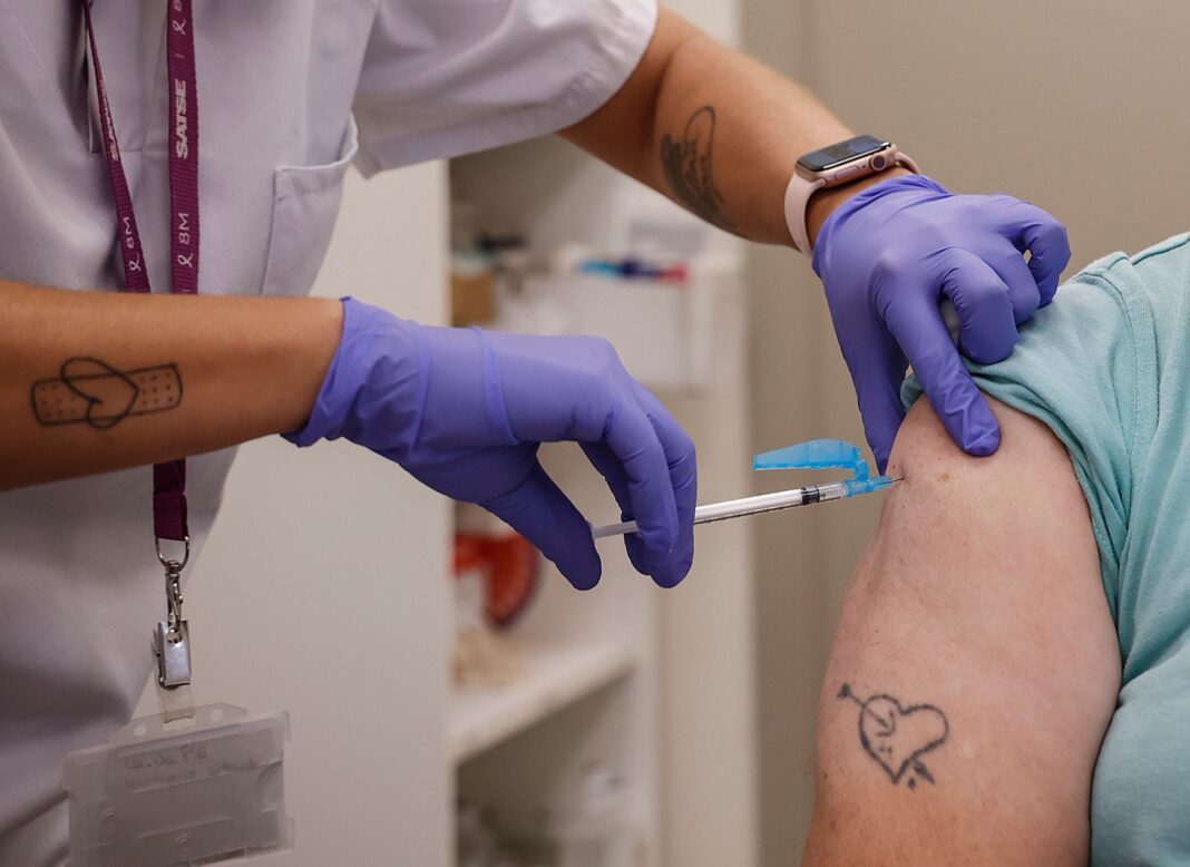 Persona recibiendo una vacuna en un consultorio médico.