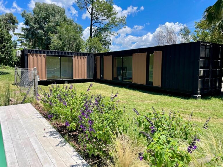 Casa moderna construida con contenedores marítimos reciclados, ubicada en un terreno argentino.