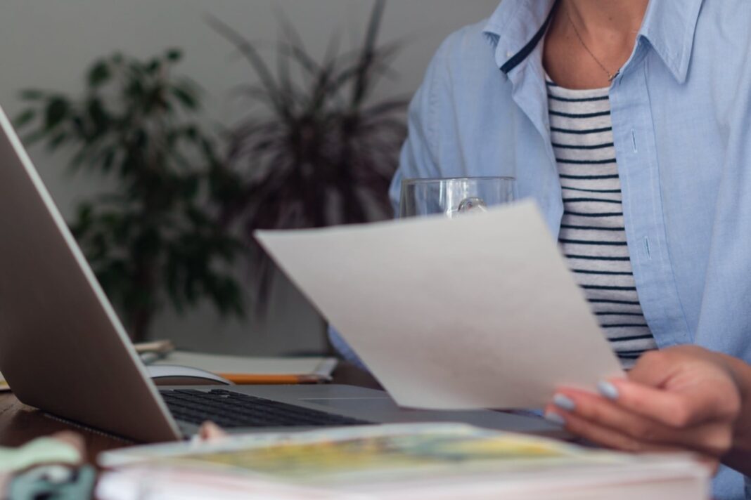Persona revisando un recibo de sueldo en Argentina con una calculadora y un lápiz.