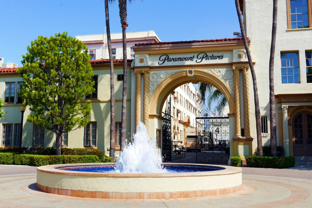 Logotipos de Paramount y Warner Bros. Discovery sobre fondo abstracto