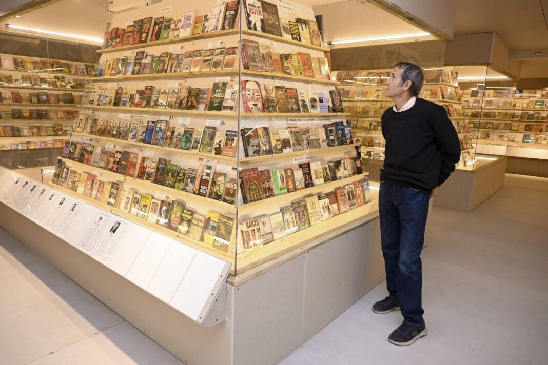 Vista interior del Museo del Libro en Punta del Este, mostrando vitrinas iluminadas con libros organizados en estructuras piramidales.