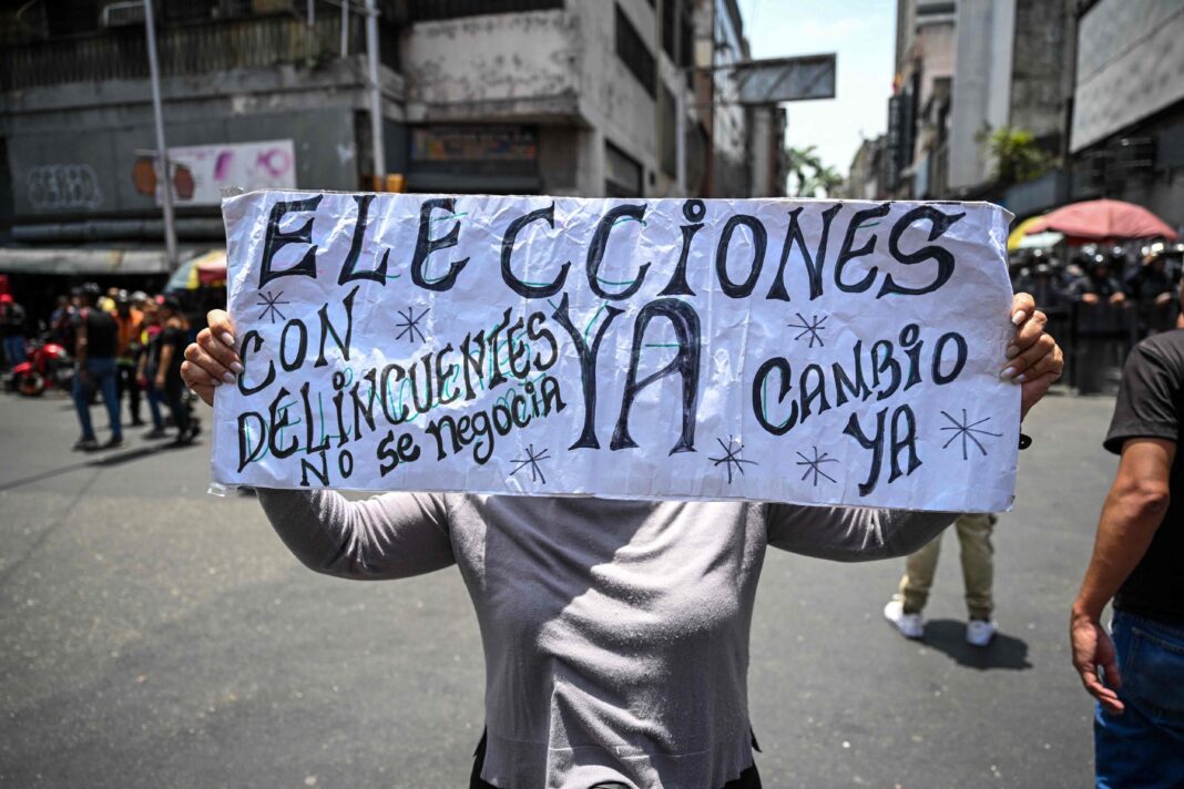 Manifestación opositora en Caracas, Venezuela, con banderas y carteles pidiendo elecciones.