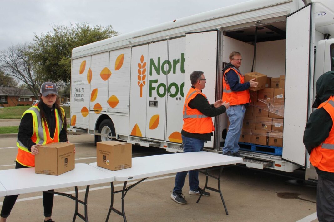 Voluntarios repartiendo cajas de alimentos en un punto de distribución en Texas.