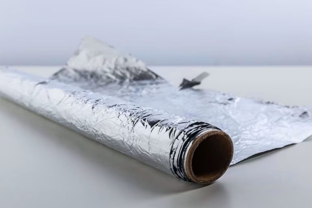 Persona colocando papel aluminio en una pared para probar la presencia de humedad.