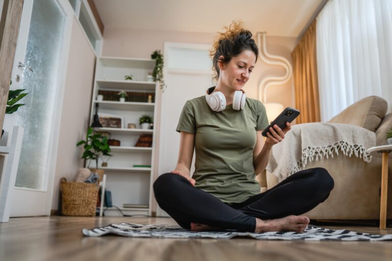 Persona usando redes sociales en un teléfono móvil, con expresión de agotamiento y presión por la vida optimizada