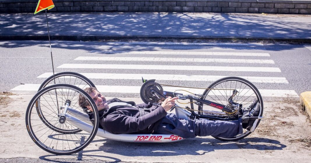 Luciano Llosa en su silla de ruedas con su handbike en la playa
