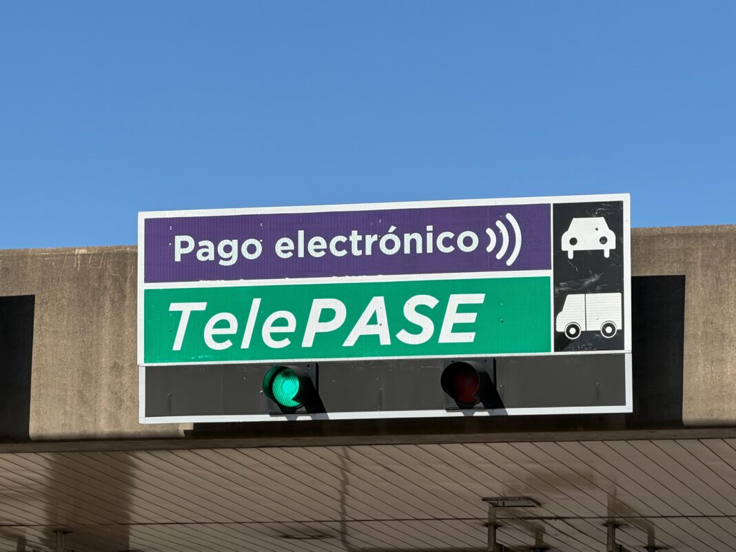 Cabina de peaje con señalización violeta de pago electrónico en Acceso Norte